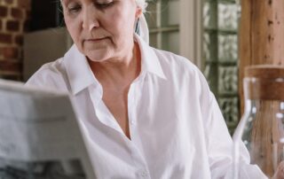 Woman Reading Newspaper and eating spaghetti