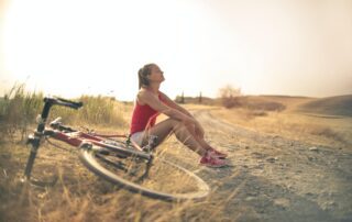 Woman with face to the sun and bicycle