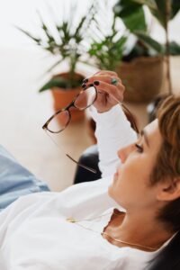 Worried woman reclining with glasses