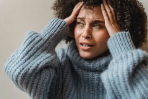 Distraught woman in blue turtleneck