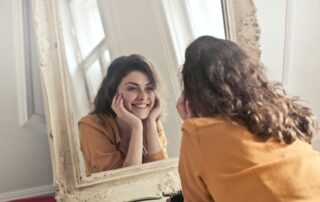 Woman looking in mirror smiling