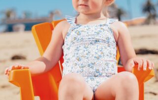 Blonde girl sitting in chair on beach