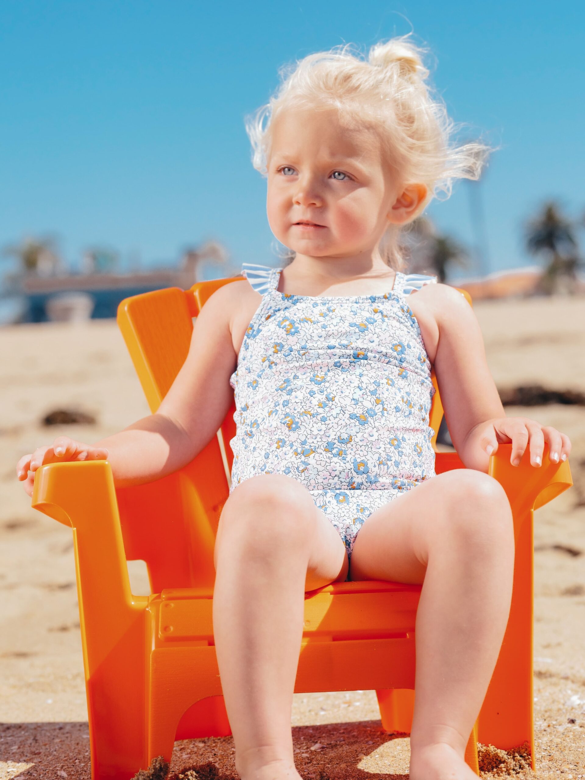 Blonde girl sitting in chair on beach