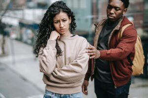 Woman appearing troubled with man reaching for her