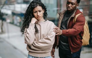 Woman appearing troubled with man reaching for her