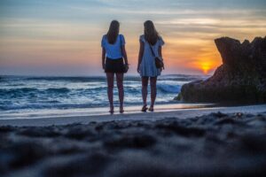 Two women walking on beach