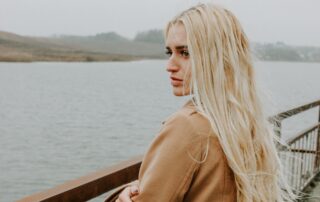 Woman standing with arms crossed on bridge