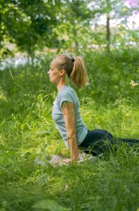 Woman outside in upward facing dog position