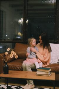 Woman sitting on couch with little girl in her lap
