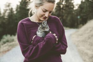 Woman outside snuggling a kitten