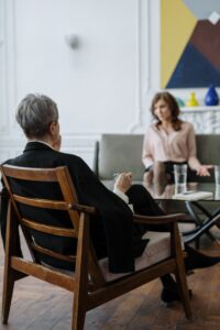 Woman on sofa talking to woman in chair