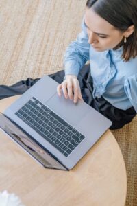 Woman sitting on floor looking at laptop