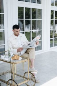 Man sitting outside reading newspaper