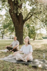 Man and woman sitting under tree meditating