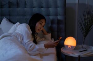 Woman in bed looking at cell phone at 1:05 am