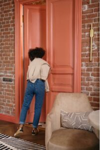 Woman opening an orange door