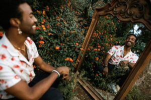 Man looking in mirror in a lantana garden