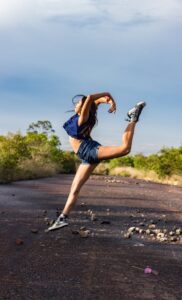 Woman wearing sneakers, shorts and t-shirt dancing outside