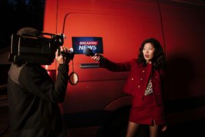 Female reporter with microphone in front of an marked Breaking News with camera person