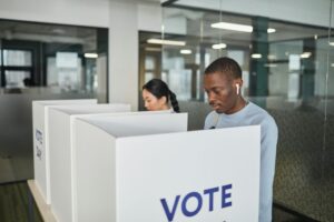 Two people standing at voting booths