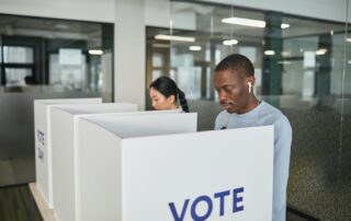 Two people standing at voting booths